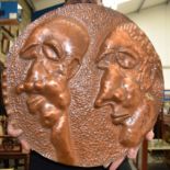 AN AFRICAN COPPER PLAQUE, depicting the elongated faces of two brothers.49 cm wide.