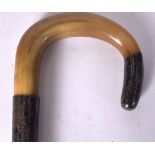 AN EARLY 20TH CENTURY BLOND RHINOCEROS HORN HANDLED WALKING STICK, formed with a silver collar and