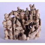 A 19TH CENTURY JAPANESE MEIJI PERIOD CARVED IVORY OKIMONO modelled with numerous figures in various