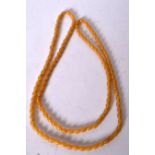 AN AMBER NECKLACE, formed with flattened spherical beads. 100 cm long.