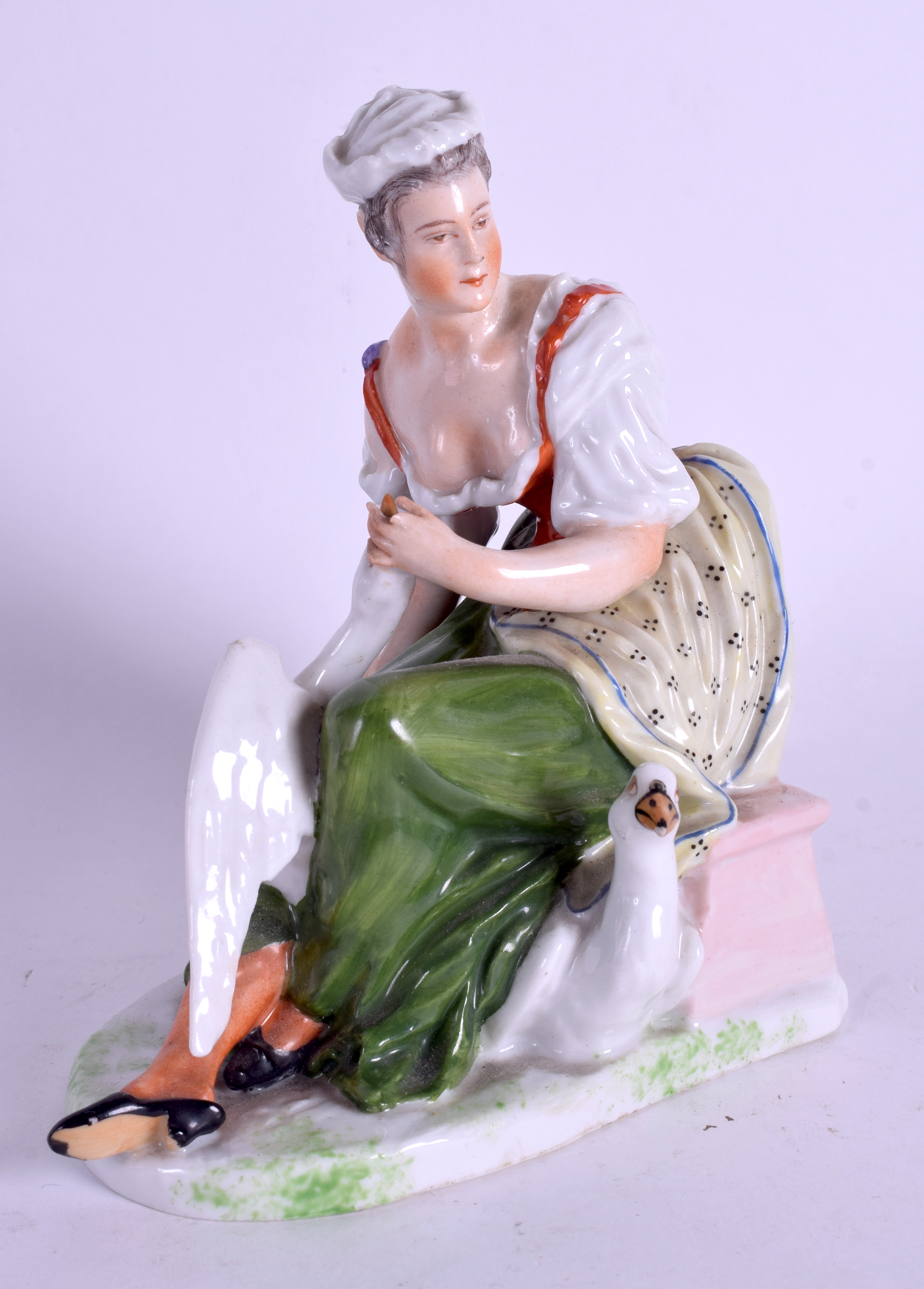 A 19TH CENTURY GERMAN SITZENDORF FIGURE OF A FEMALE modelled beside swans. 13 cm x 15 cm.