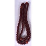 A LARGE CHINESE RED BEAD NECKLACE, carved with symbols and black spacers. 126 cm long.