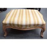 AN UPHOLSTERED WOODEN FOOT STOOL, formed upon four curving legs. 30 cm x 70 cm.