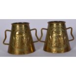 A PAIR EARLY 20TH CENTURY TWIN HANDLED BRASS VASE, decorated with a figure in a crest. 9 cm x 11 c