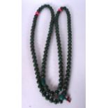 A LONG EASTERN CARVED HARDSTONE NECKLACE, formed with flattened beads and pink pumpkin shaped space