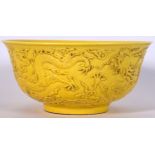 A CHINESE YELLOW GLAZED PORCELAIN BOWL, decorated with dragons amongst the clouds. 15.5 cm wide.