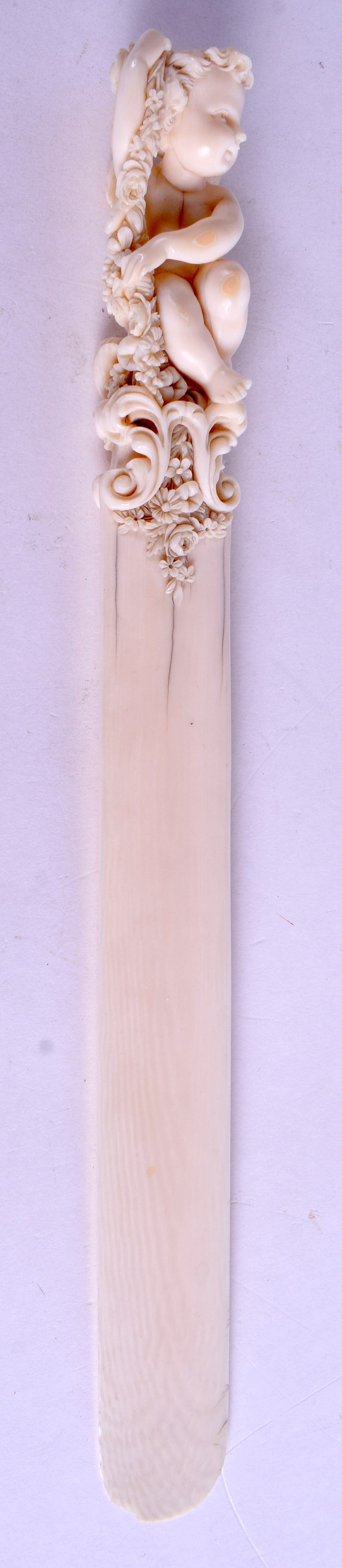 A GOOD 19TH CENTURY EUROPEAN DIEPPE IVORY LETTER OPENER carved with a putti holding foliage. 30 cm