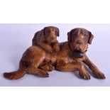 AN EARLY 20TH CENTURY BLACK FOREST BAVARIAN GROUP OF DOGS modelled recumbent. 21 cm x 13 cm.