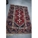 AN ANTIQUE BLUE GROUND KAZAK RUG, decorated with geometric symbols. 177 cm x 118 cm.