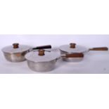 A SET OF THREE GEORG JENSEN STAINLESS STEEL SAUCEPAN, formed with tapering wooden handles, bearing