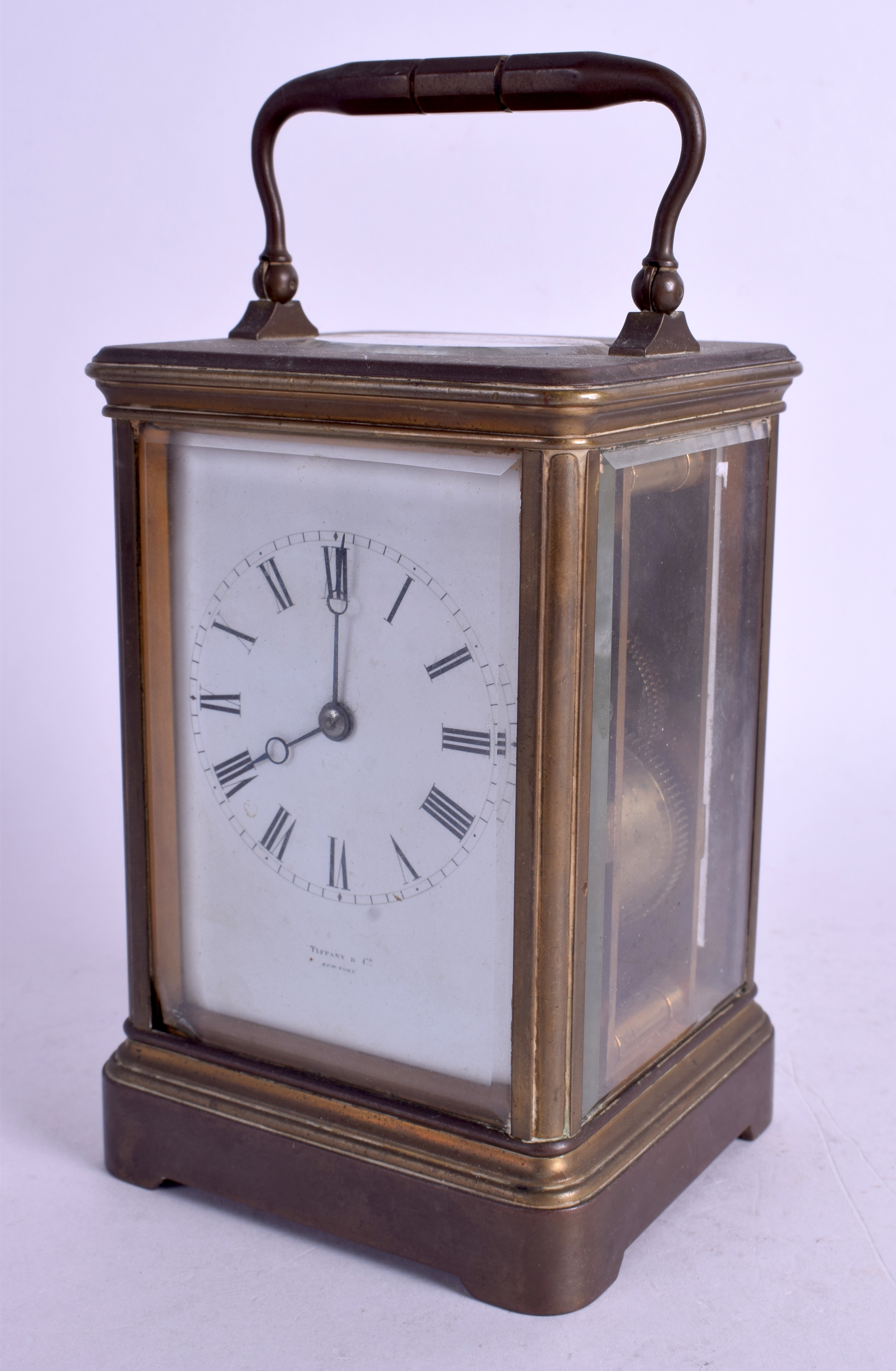 AN ANTIQUE TIFFANY & CO BRASS STRIKING CARRIAGE CLOCK. 17.5 cm high inc handle.