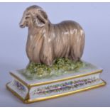 A MICHAEL SUTTY PORCELAIN FIGURINE OF A RAM, modelled upon a floral base. 10.5 cm wide.