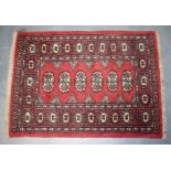 AN EARLY 20TH CENTURY RED GROUND TEKKE TURKMEN PRAYER MAT RUG, decorated with geometric motifs. 91
