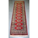 AN EARLY 20TH CENTURY TEKKE TURKMEN RUNNER RUG, decorated with geometric motifs. 250 cm x 78 cm.