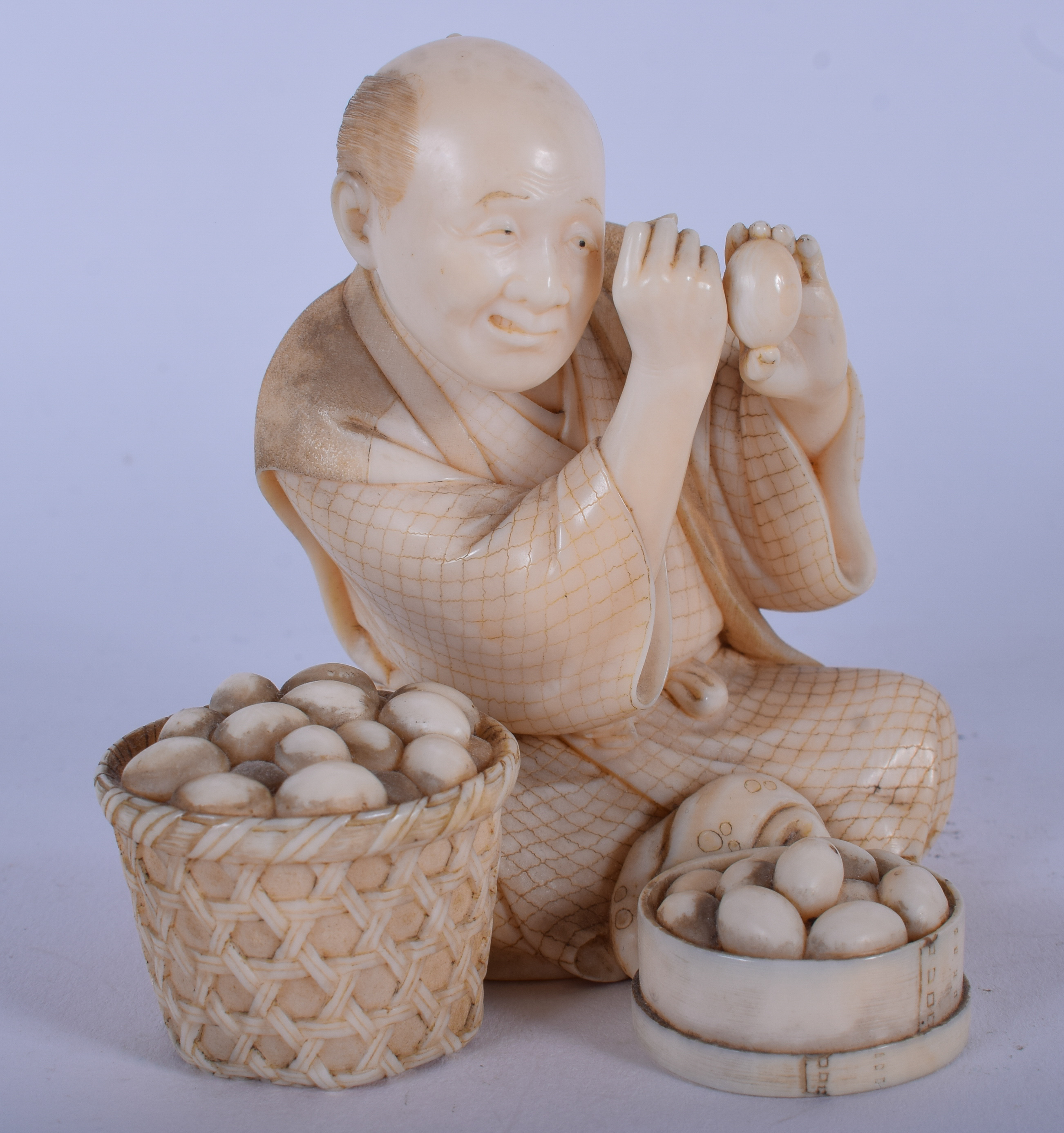 A LOVELY 19TH CENTURY JAPANESE MEIJI PERIOD CARVED IVORY OKIMONO modelled as a male inspecting eggs