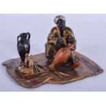 A COLD PAINTED BRONZE MALE modelled on a rug. 11 cm x 6 cm.