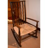 AN ANTIQUE OAK CHILDS ROCKING CHAIR, formed with thatched seat. 82 cm x 49 cm.