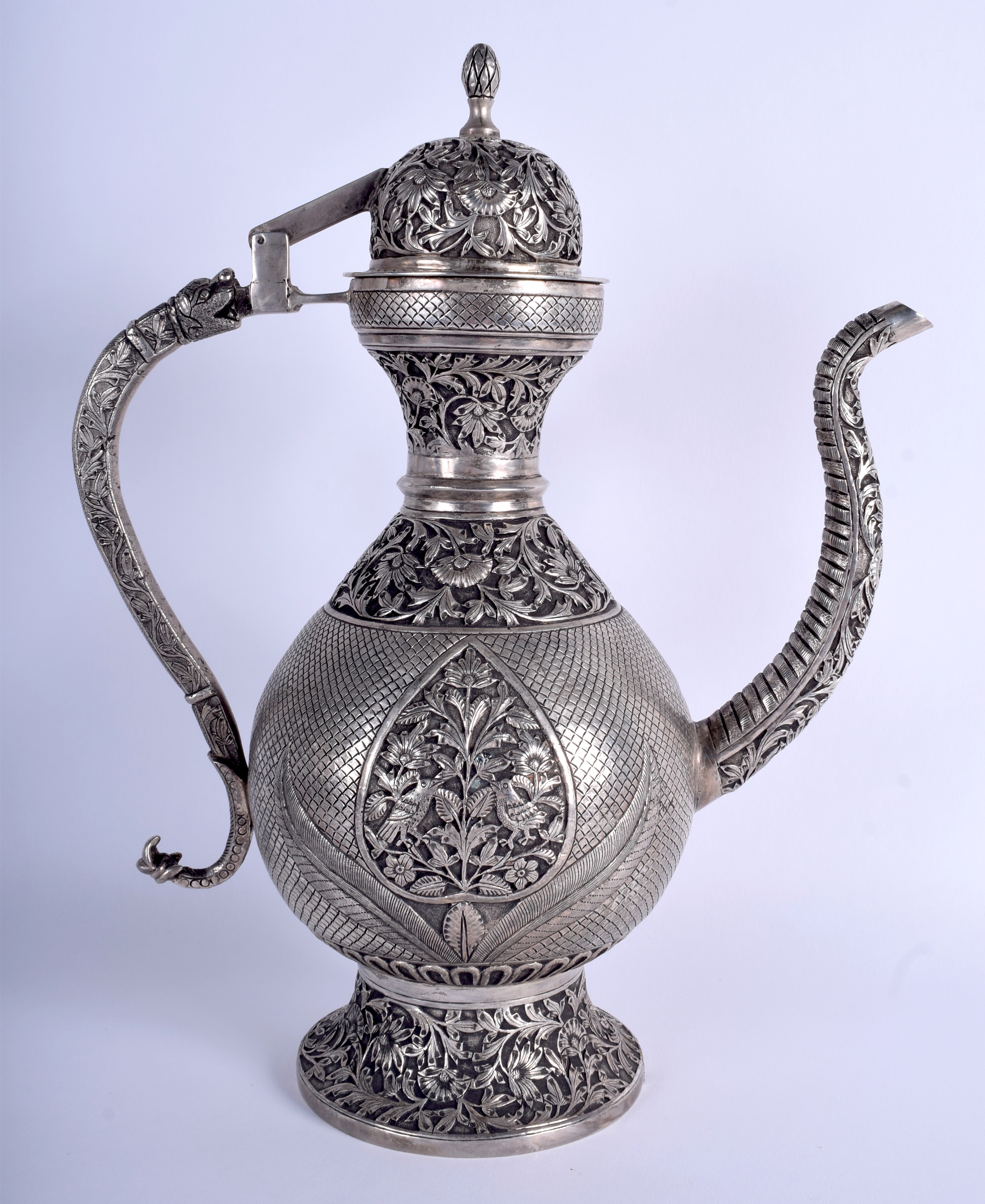 A LARGE INDIAN WHITE METAL KUFIC ISLAMIC COFFEE POT AND COVER decorated with birds and foliage. 35