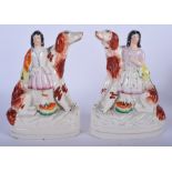 A PAIR OF 19TH CENTURY STAFFORDSHIRE POTTERY POODLES, formed with figures embracing them. 20 cm hig