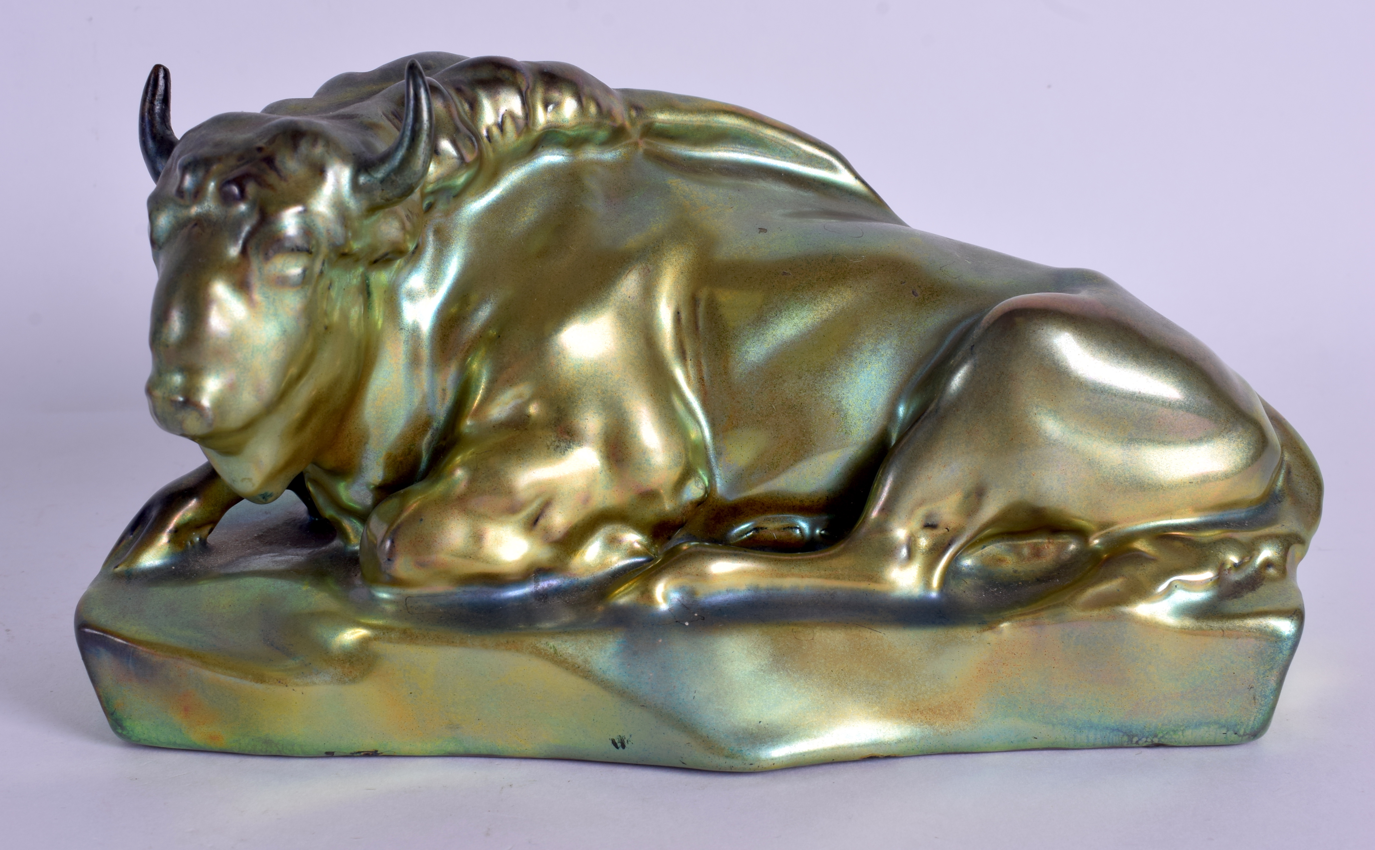 AN UNUSUAL HUNGARIAN ZSOLNAY PECS LUSTRE FIGURE OF A BULL modelled recumbent. 22 cm x 11 cm.