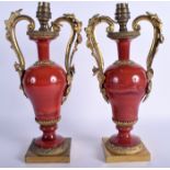 A PAIR OF MID 19TH CENTURY FRENCH TWIN HANDLED ORMOLU AND RED STONE VASES overlaid with foliage. 32