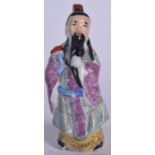 AN EARLY 20TH CENTURY CHINESE FAMILLE ROSE PORCELAIN FIGURE OF A SCHOLAR, formed standing holding a