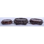 THREE 19TH CENTURY CHINESE CARVED HONGMU HARDWOOD STANDS. Largest 16.5 cm wide. (3)