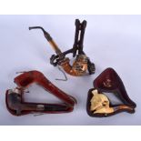 THREE ANTIQUE PIPES together with a stand. (4)