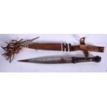 A WEST AFRICAN DAGGER, formed with leather scabbard. 33 cm.