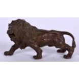 A BRONZE SCULPTURE IN THE FORM OF A LION, modelled prowling. 7.6 cm wide.