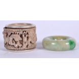 A 20TH CENTURY CHINESE WHITE METAL REVOLVING RING, together with a jadeite ring. 3 cm wide. (2)
