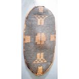 A GOOD ANTIQUE AFRICAN TRIBAL WICKER WARRIOR SHIELD decorated with geometric motifs. 111 cm x 50 cm