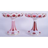 A PAIR OF BOHEMIAN CRANBERRY WHITE OVERLAID GLASS COMPORTS. 16 cm x 16 cm.