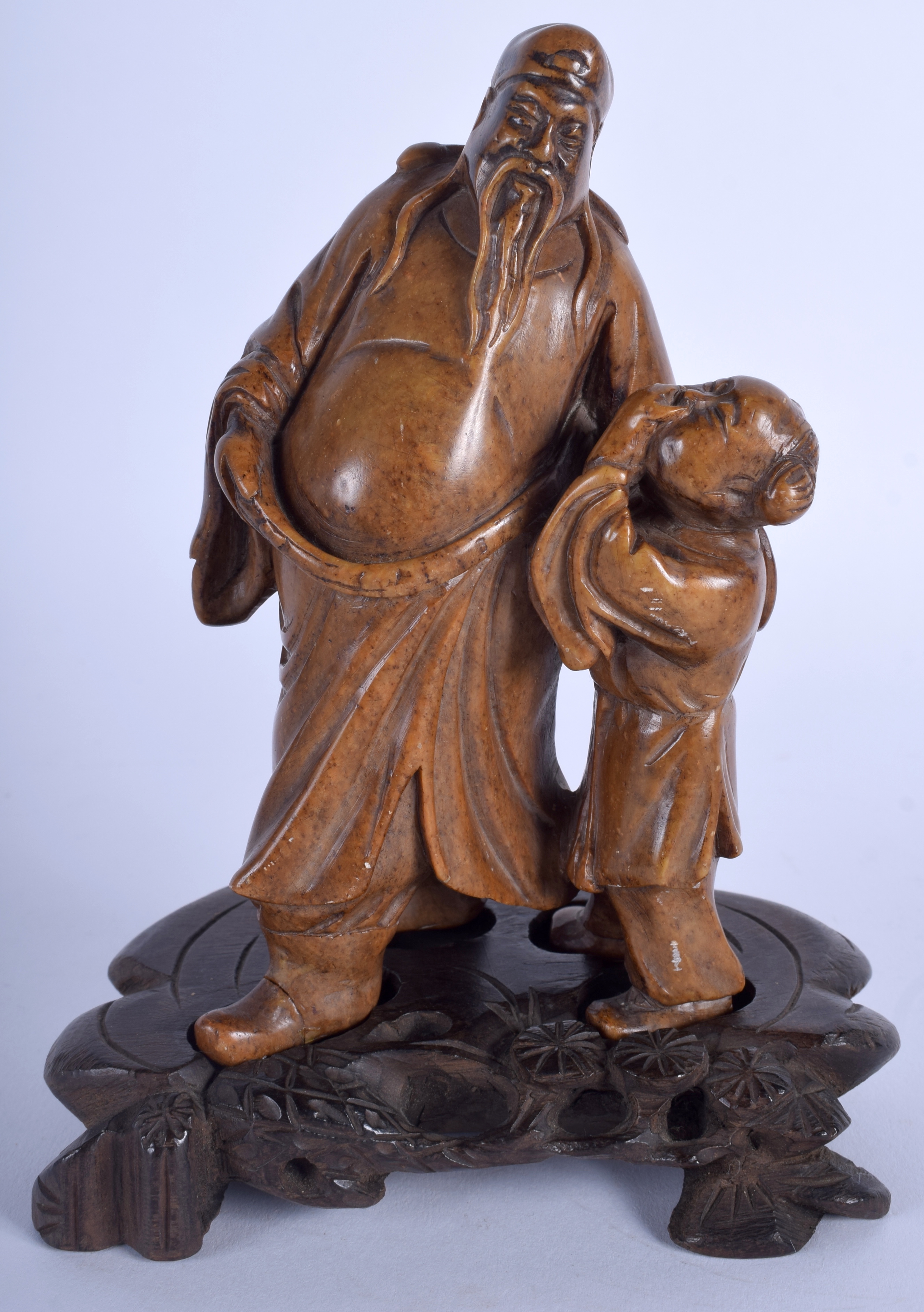 A 19TH CENTURY CHINESE CARVED HARDSTONE FIGURE OF A SCHOLAR modelled beside a laughing boy. 15 cm x