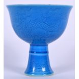 A CHINESE BLUE GLAZED PORCELAIN STEM BOWL BEARING MING MARKS, incised with a dragon amongst the clo