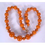 AN AMBER TYPE NECKLACE, formed with spherical beads. 48 cm long.