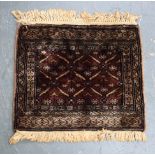 A MAROON GROUND PERSIAN PRAYER MAT TYPE RUG, decorated with geometric symbols. 47 cm x 46 cm.