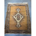 A BROWN GROUND PRAYER MAT RUG, decorated with a central geometric motif. 110 cm x 76 cm.