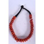 A CHINESE RED CORAL NECKLACE, formed with flattened naturalistic beads. 44 cm long.