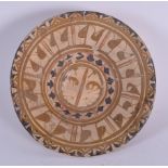 AN ANTIQUE IRANIAN POTTERY BOWL, decorated with symbols. 23.5 cm wide.