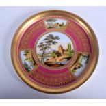 A 19TH CENTURY VIENNA STYLE DISH painted with landscapes on a rose ground. 21 cm diameter.