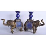 A PAIR OF EARLY 20TH CENTURY CHINESE BRASS AND ENAMEL VASES AND COVERS in the form of elephants. 28