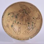 A PERSIAN POTTERY BOWL, decorated internally with a figure on horseback. 20 cm wide.