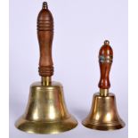 A BRASS BELL, formed with a turned wooden handle, together with a smaller example. Largest 25 cm hi