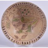 A PERSIAN POTTERY BOWL, decorated internally with a bird. 21.5 cm wide.