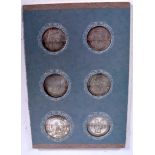 A CASED SET OF SIX CHINESE WHITE METAL COINS, varying decoration. Coins 3.2 cm diameter.
