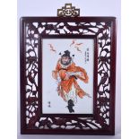 A CHINESE HARDWOOD FAMILLE ROSE PORCELAIN INSET PANEL OR PLAQUE, painted with a figure surrounded b