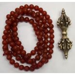 A TIBETAN WHITE RITUAL OBJECT, together with an agate bead necklace. Necklace 104 cm long. (2)