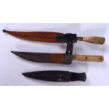 AN EARLY 20TH CENTURY RHINOCEROS HORN HANDLED DAGGER, together with two others similar. Longest 19.