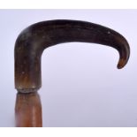 AN EARLY 20TH CENTURY RHINOCEROS HORN HANDLED WALKING STICK, formed with a walnut shaft. 82.5 cm lo
